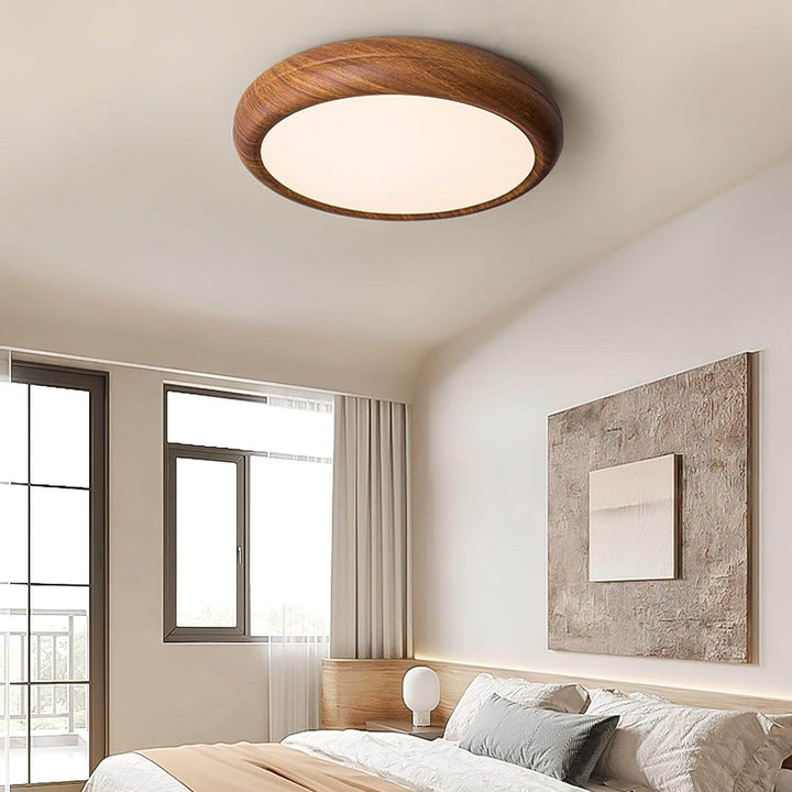 Lampa sufitowa okrągła drewniana, na tle ściany