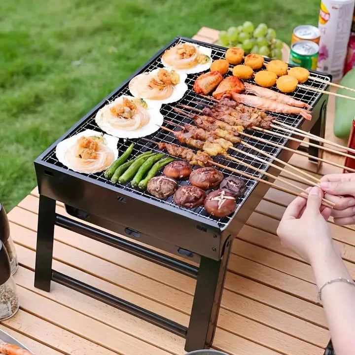 Lekki i kompaktowy składany metalowy grill stołowy, idealny na kemping, z solidną metalową konstrukcją i stalowym rusztem.
