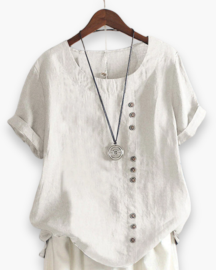 Luźna letnia bluzka damska zapinana na guziki, lekka, szykowna, z płynnego materiału i wyrafinowanymi detalami.