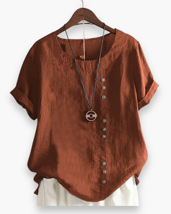 Luźna letnia bluzka damska zapinana na guziki, lekka, szykowna, z płynnego materiału i wyrafinowanymi detalami.