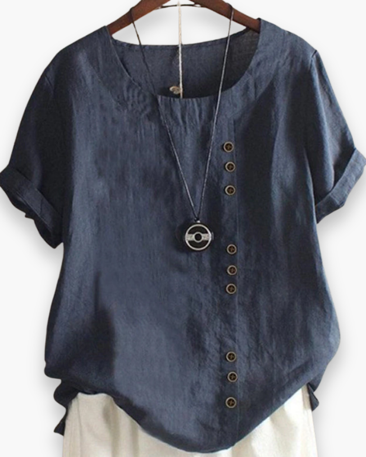 Luźna letnia bluzka damska zapinana na guziki, lekka, szykowna, z płynnego materiału i wyrafinowanymi detalami.