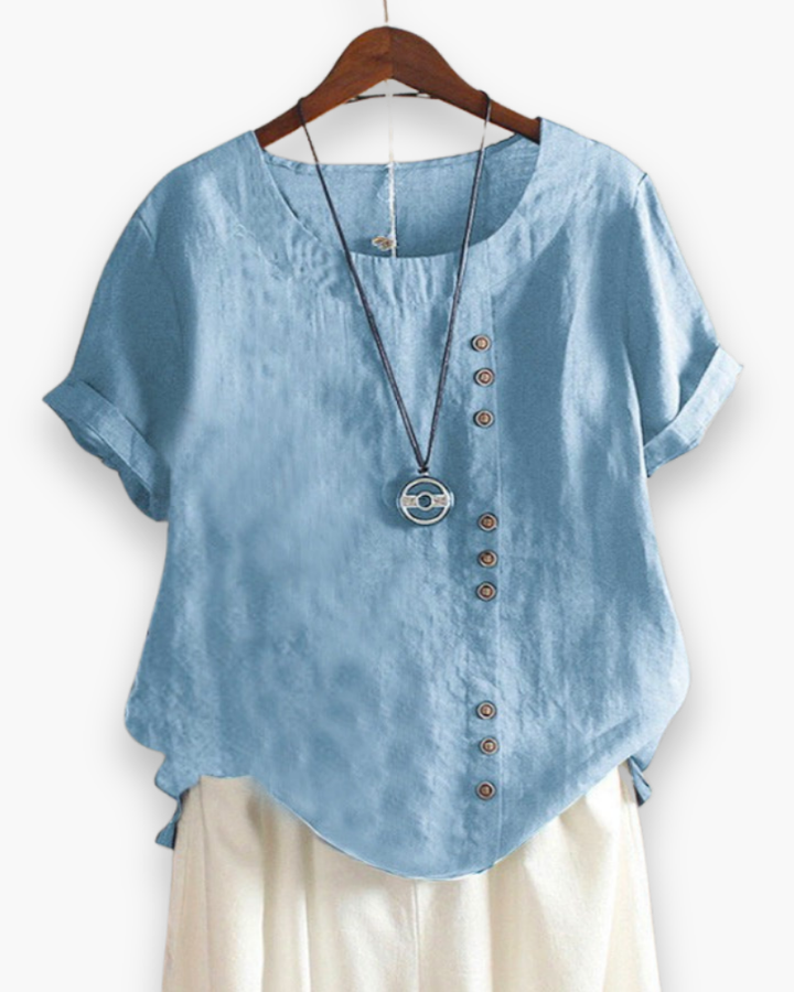 Luźna letnia bluzka damska zapinana na guziki, lekka, szykowna, z płynnego materiału i wyrafinowanymi detalami.