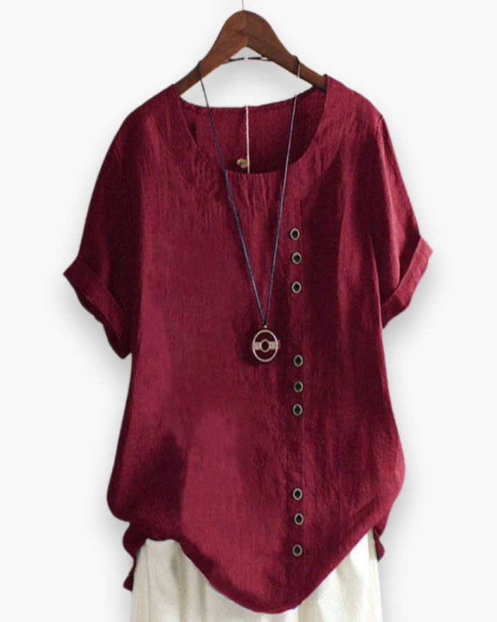 Luźna letnia bluzka damska zapinana na guziki, lekka, szykowna, z płynnego materiału i wyrafinowanymi detalami.