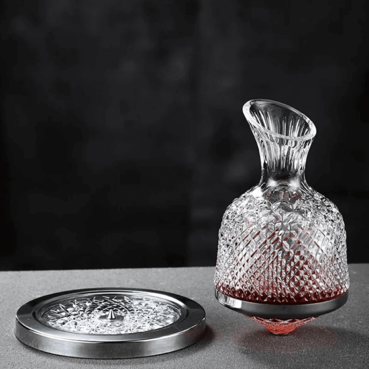 Obrotowa kryształowa karafka do wina, elegancki i nowoczesny design, srebrne wykończenie, na białym tle.