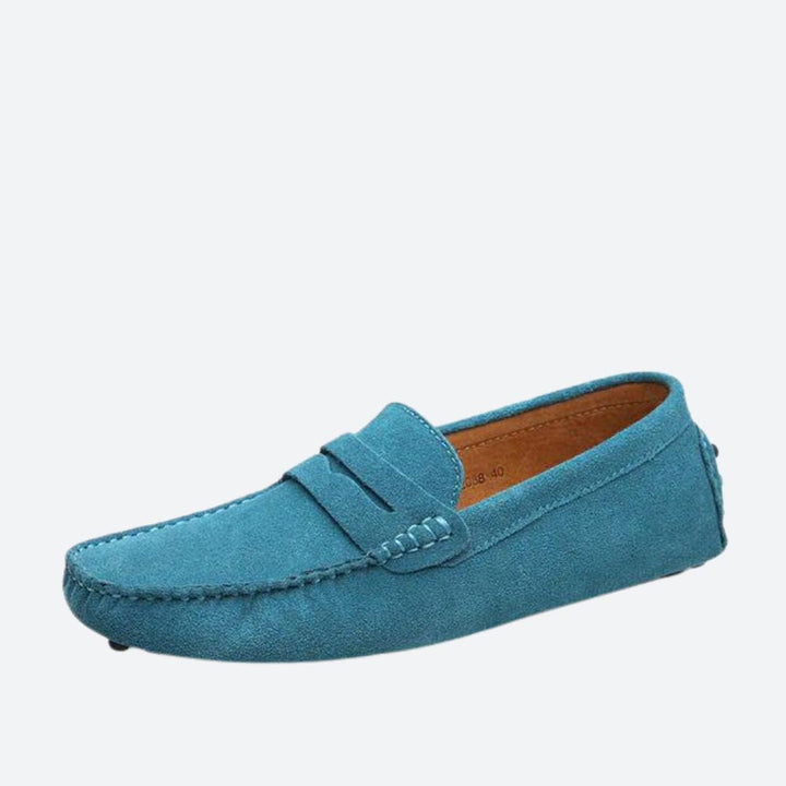 Błękitne eleganckie buty skórzane męskie, na białej powierzchni.