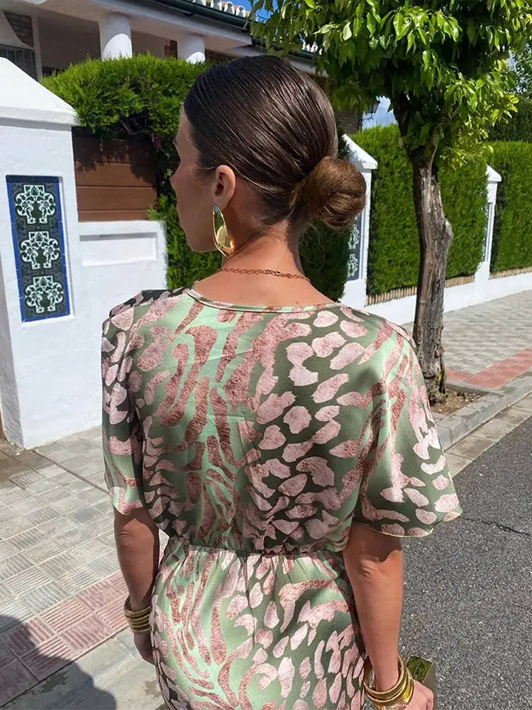 Kobieta w damskiej sukience kopertowej midi z dekoltem V, eleganckiej i wygodnej.