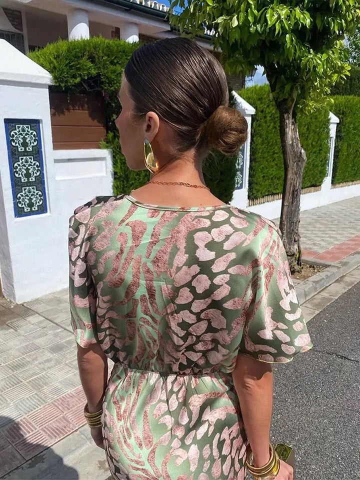 Kobieta w damskiej sukience kopertowej midi z dekoltem V, eleganckiej i wygodnej.