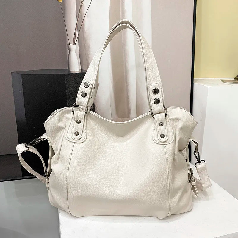 Szczegóły eleganckiej torby shopper ze skóry groszkowanej, ukazujące wewnętrzne kieszenie i regulowany pasek na ramię