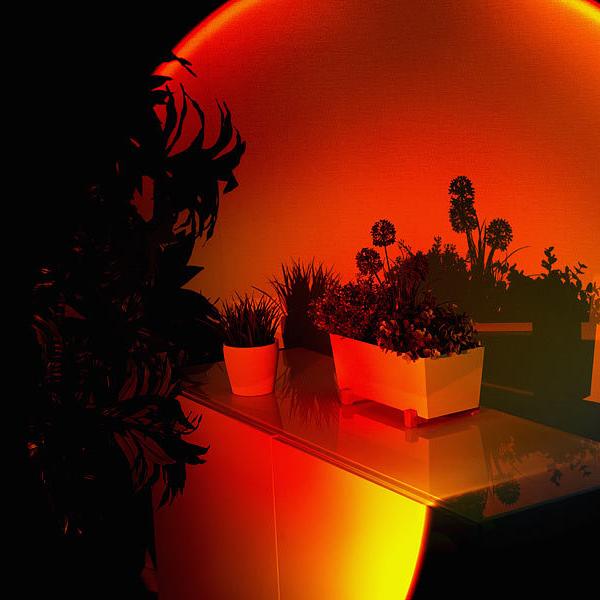 Lampa Sunset Lamp LED do pokoju, tworząca iluzję zachodzącego słońca na ścianie.