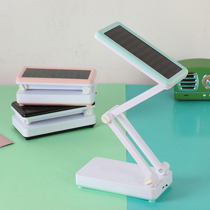 Składana lampa LED solarna, kompaktowa konstrukcja, w kolorach białym, różowym, zielonym do wnętrz i na zewnątrz.