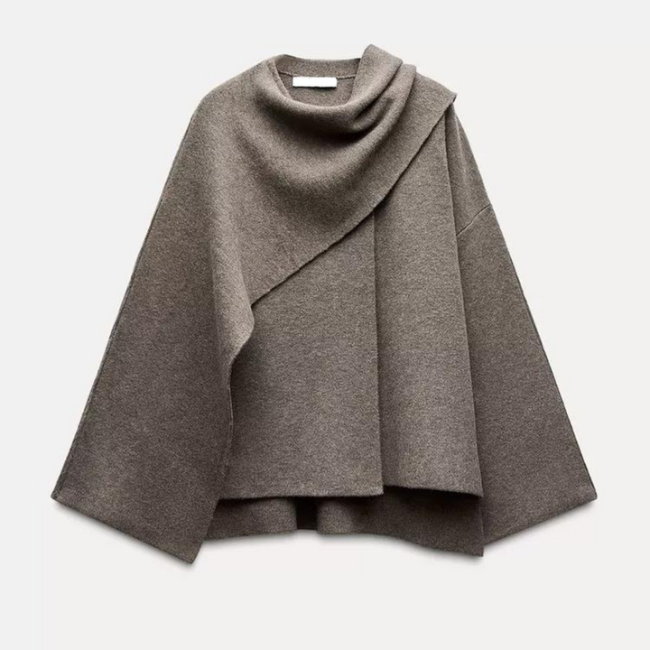 Damski elegancki jesienny płaszcz-peleryna, asymetryczny design w kolorze szarym, miękki materiał, nowoczesny i wygodny styl na chłodne dni.