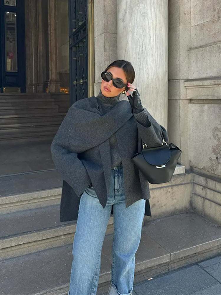 Damski elegancki jesienny płaszcz-peleryna, asymetryczny design w kolorze szarym, miękki materiał, nowoczesny i wygodny styl na chłodne dni.