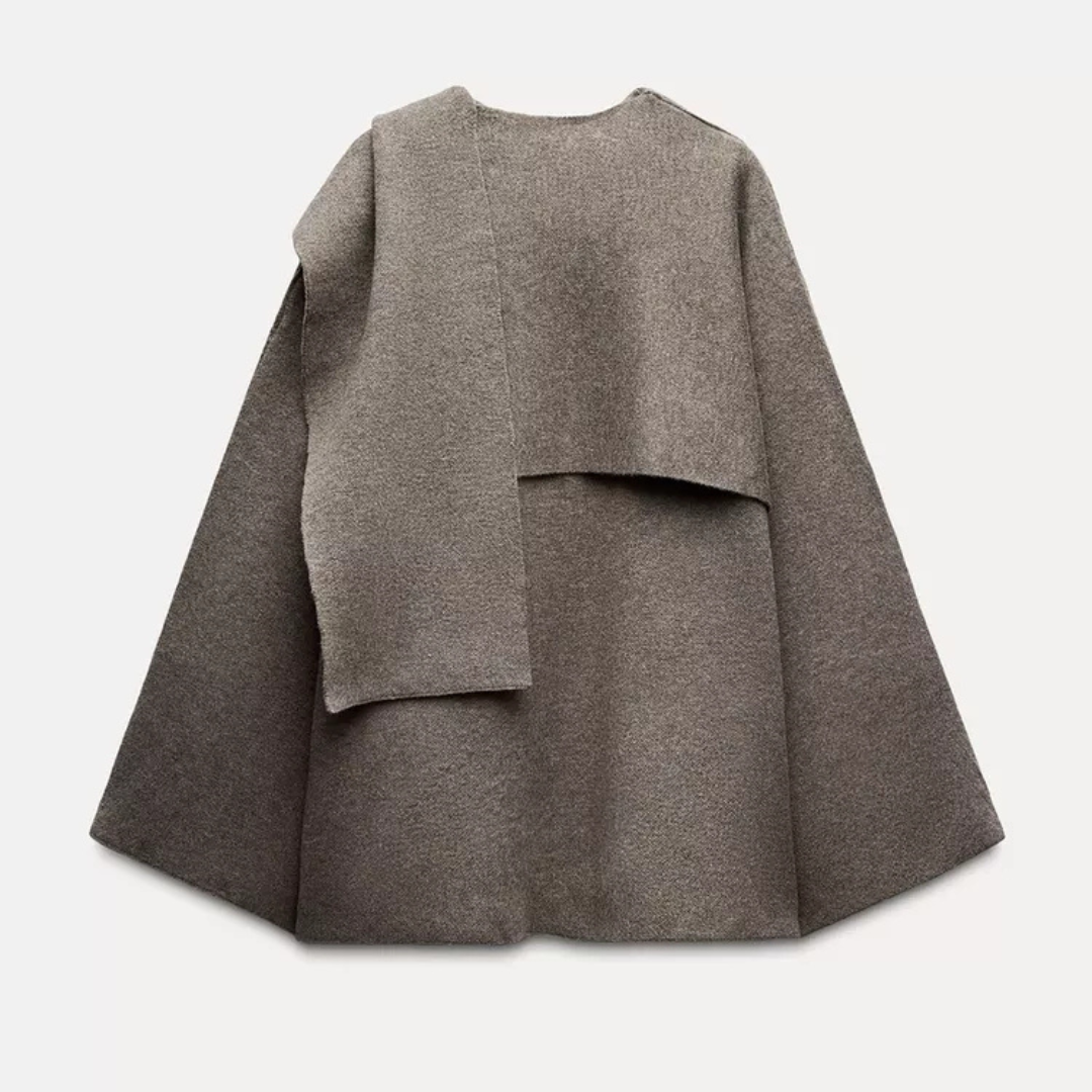 Damski elegancki jesienny płaszcz-peleryna, asymetryczny design w kolorze szarym, miękki materiał, nowoczesny i wygodny styl na chłodne dni.