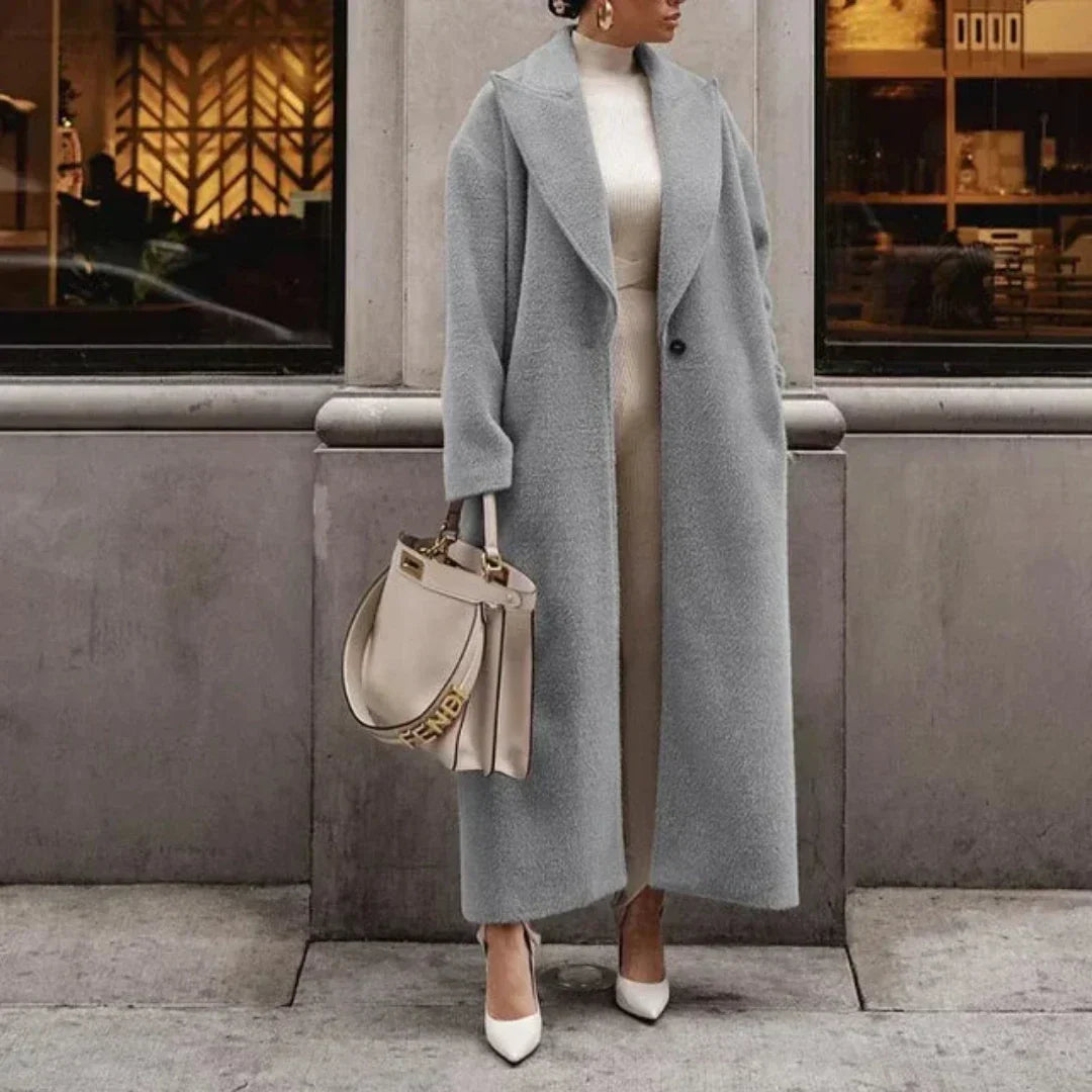 Kobieta w eleganckim długim płaszczu zimowym, podkreślającym smukłą sylwetkę i dającym poczucie luksusu.