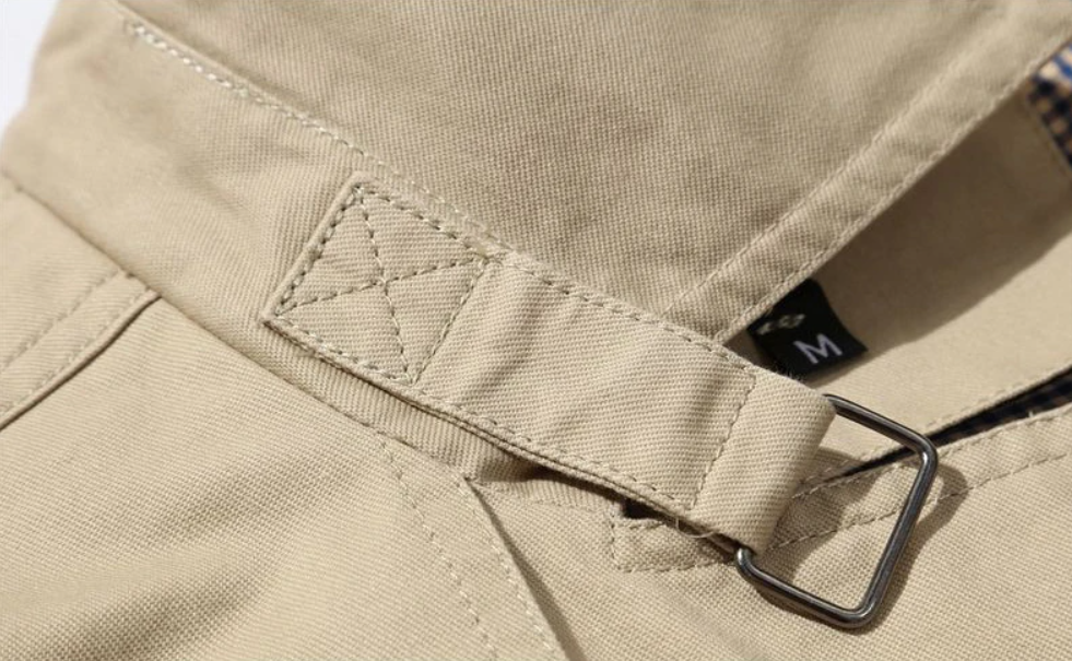 Elegancki męski płaszcz trenczowy o strukturalnym kroju, gładkiej podszewce, wyraźnych naramiennikach i wyrafinowanym podwójnym zapinaniu.