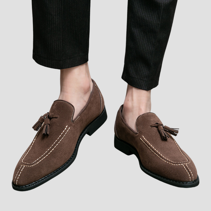 Męskie mokasyny z zamszu, widok z góry, w kolorze ciemnego brązu z eleganckimi chwostami, gumowa podeszwa, wyrafinowany styl.