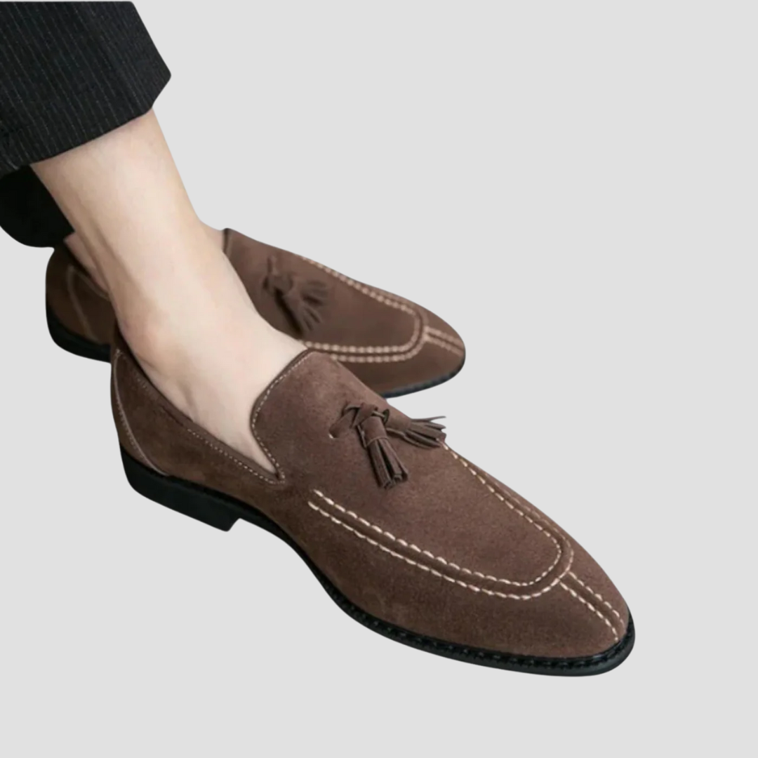 Męskie mokasyny z zamszu, widok z góry, w kolorze ciemnego brązu z eleganckimi chwostami, gumowa podeszwa, wyrafinowany styl.