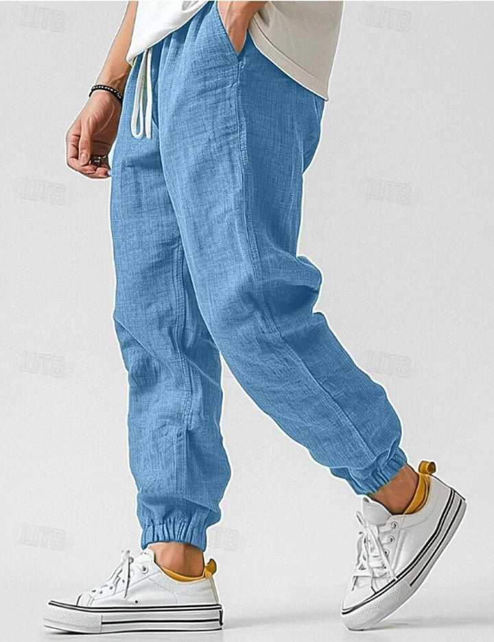 Męskie beżowe spodnie lniane, lekkie i oddychające, w stylu casual na lato, zapewniające komfort i elegancję.