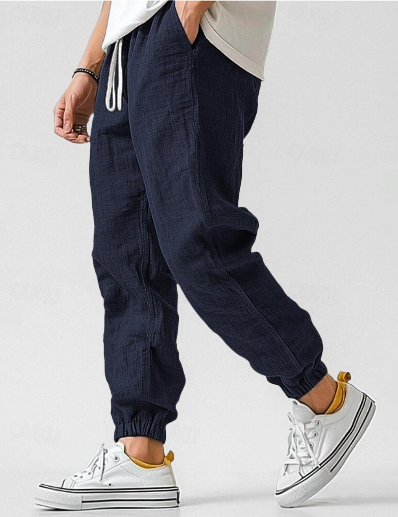 Męskie granatowe spodnie lniane, lekkie i oddychające, w stylu casual na lato, zapewniające komfort i elegancję.