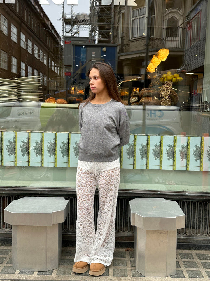 Rozkloszowane spodnie z wysokim stanem z czarnej koronki, wyszczuplająca sylwetka, przezroczysty kwiatowy wzór dla eleganckiego wyglądu.