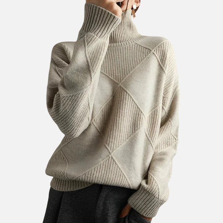 Szczegółowa tekstura luksusowego damskiego swetra kaszmirowego z golfem, podkreślająca diamentowy wzór.