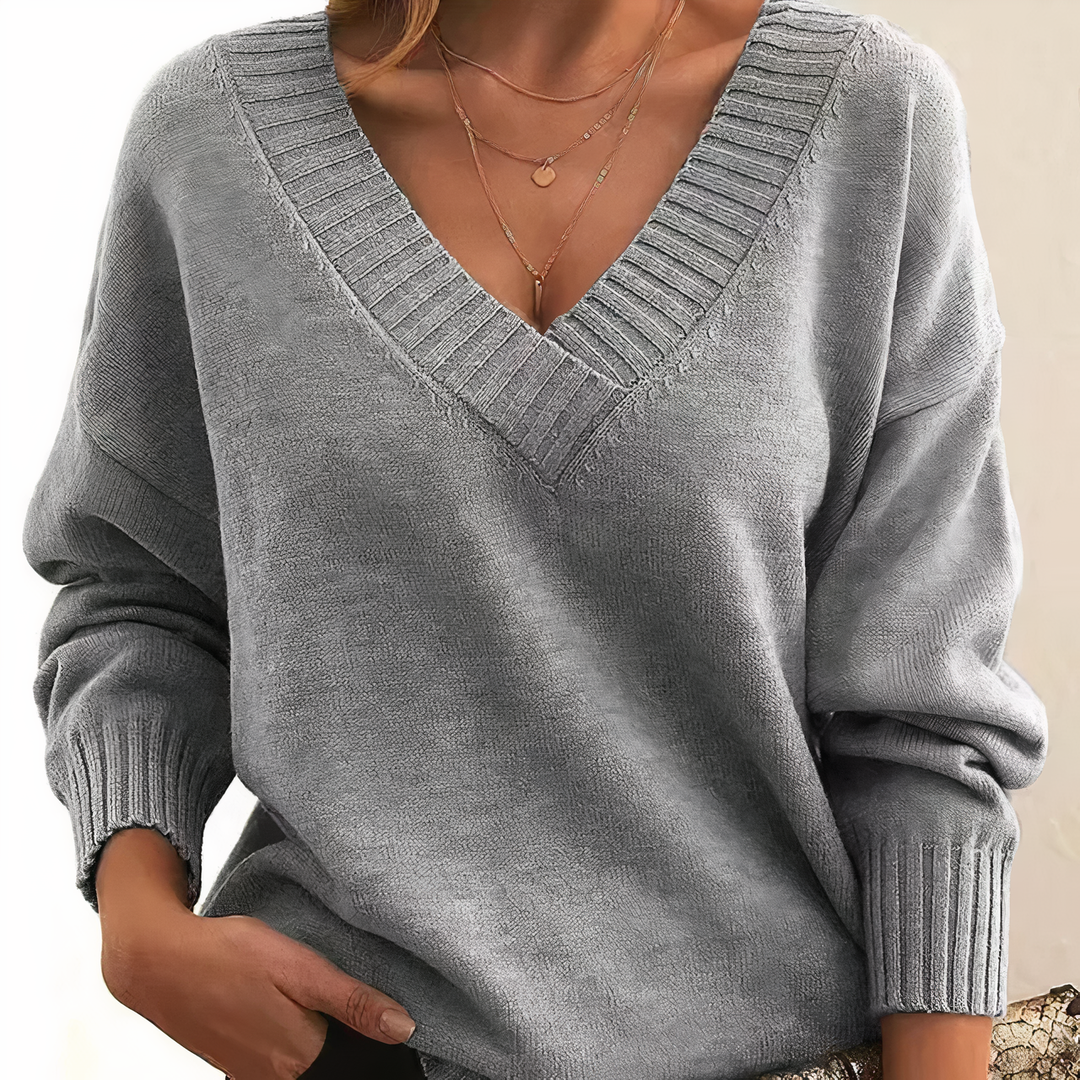 Damski sweter z dekoltem V, elegancki i miękki, na beżowym tle, idealny do codziennej elegancji i lekkiego ciepła.