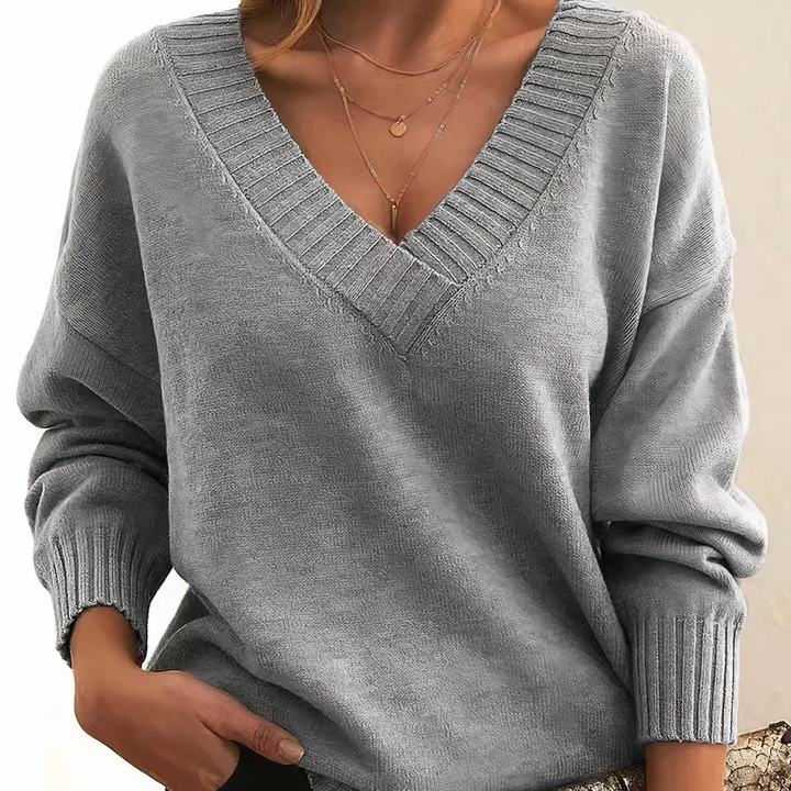 Damski sweter z dekoltem V, elegancki i miękki, na beżowym tle, idealny do codziennej elegancji i lekkiego ciepła.
