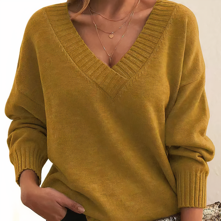 Damski sweter z dekoltem V, elegancki i miękki, na beżowym tle, idealny do codziennej elegancji i lekkiego ciepła.
