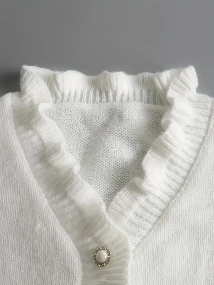 Wiosenny sweter damski z dekoltem V, bawełniany, w kolorze białym, elegancki, lekki i dopasowany, idealny do casualowych lub eleganckich stylizacji.