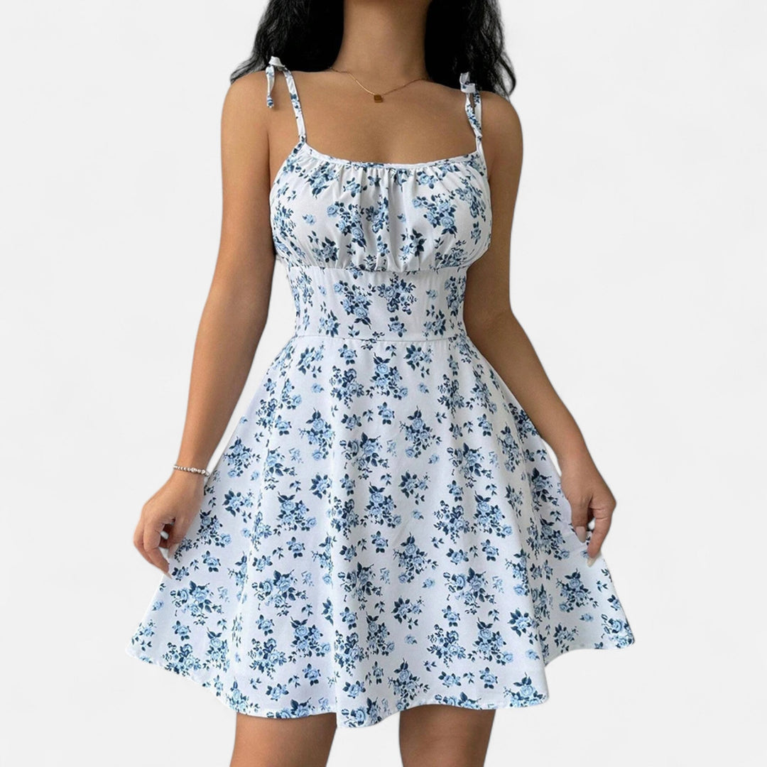 Krótka damska sukienka na cienkich ramiączkach z kwiatowym nadrukiem, lekki materiał na lato, schlebiający i kobiecy krój.