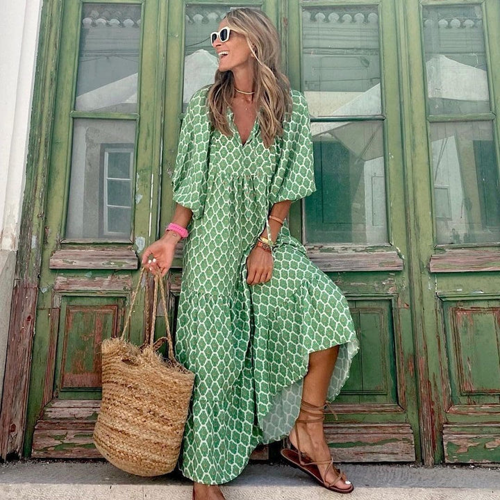 Długa sukienka boho z nadrukiem vintage, dekoltem w serek i luźnymi rękawami, idealna na letni, swobodny i elegancki wygląd.