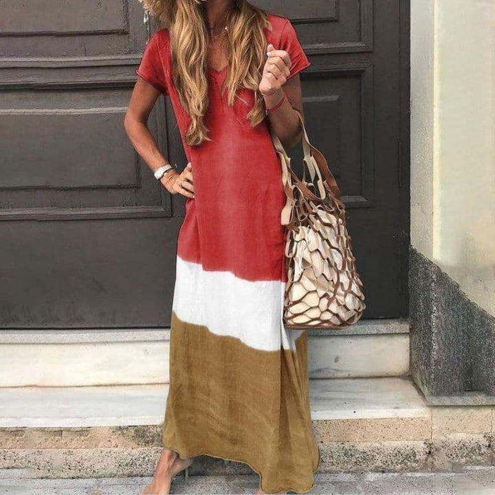 Damska sukienka maxi boho color block w odcieniach terakoty, bieli i brązu, z dekoltem V i krótkim rękawem.