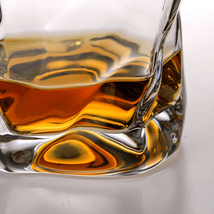Japońska szklanka do whisky Edo Kiriko o unikalnym designie ze zgniecionej butelki, z grawerowanymi wzorami i nowoczesną estetyką.