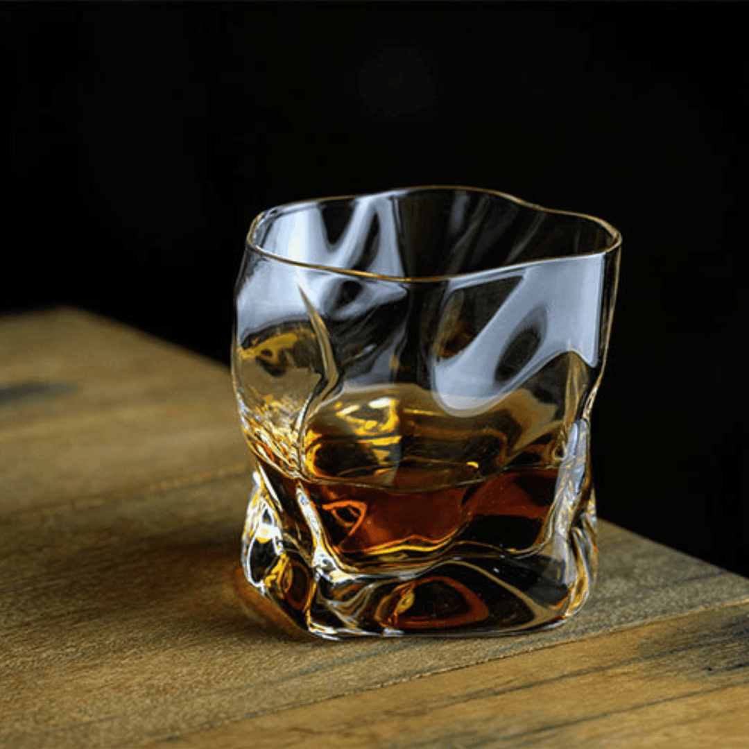 Japońska szklanka do whisky Edo Kiriko o unikalnym designie ze zgniecionej butelki, z grawerowanymi wzorami i nowoczesną estetyką.