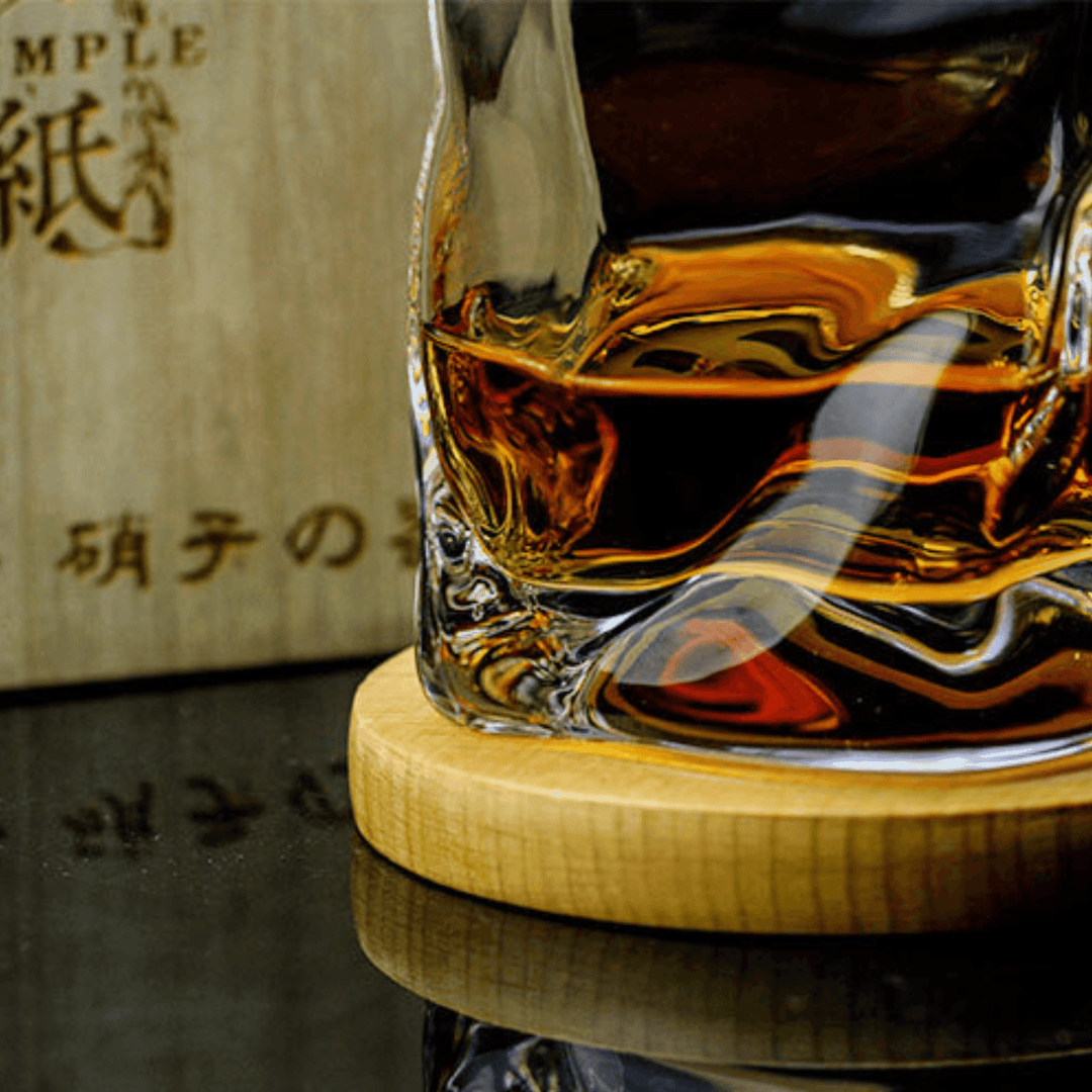 Japońska szklanka do whisky Edo Kiriko o unikalnym designie ze zgniecionej butelki, z grawerowanymi wzorami i nowoczesną estetyką.