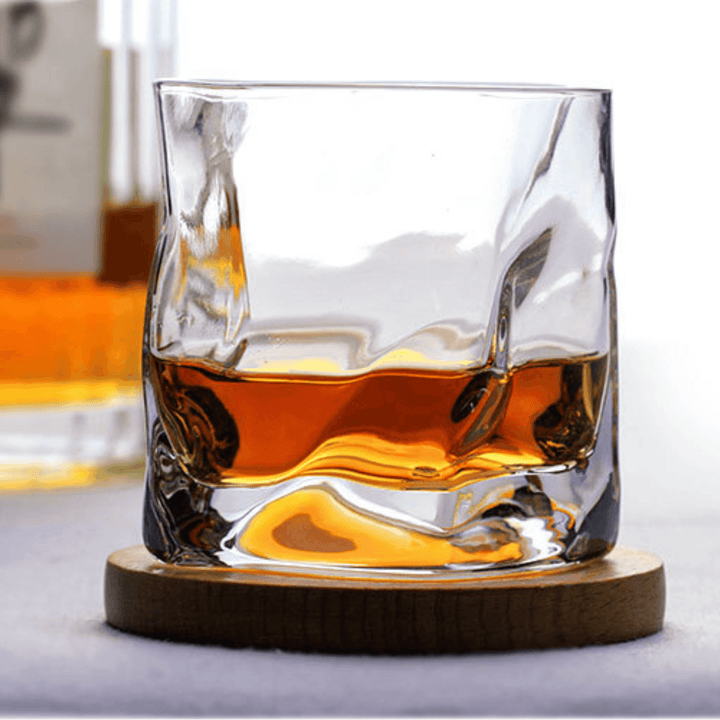 Japońska szklanka do whisky Edo Kiriko o unikalnym designie ze zgniecionej butelki, z grawerowanymi wzorami i nowoczesną estetyką.