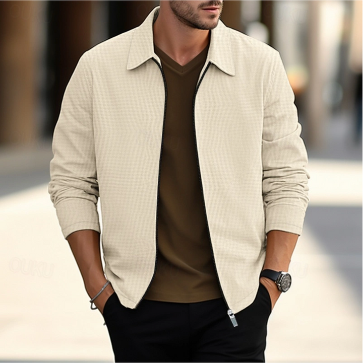 Elegancka kurtka męska wykonana z wysokiej jakości tkaniny, dostępna w różnych kolorach, odpowiednia do pracy lub wypoczynku, łącząca komfort i styl.